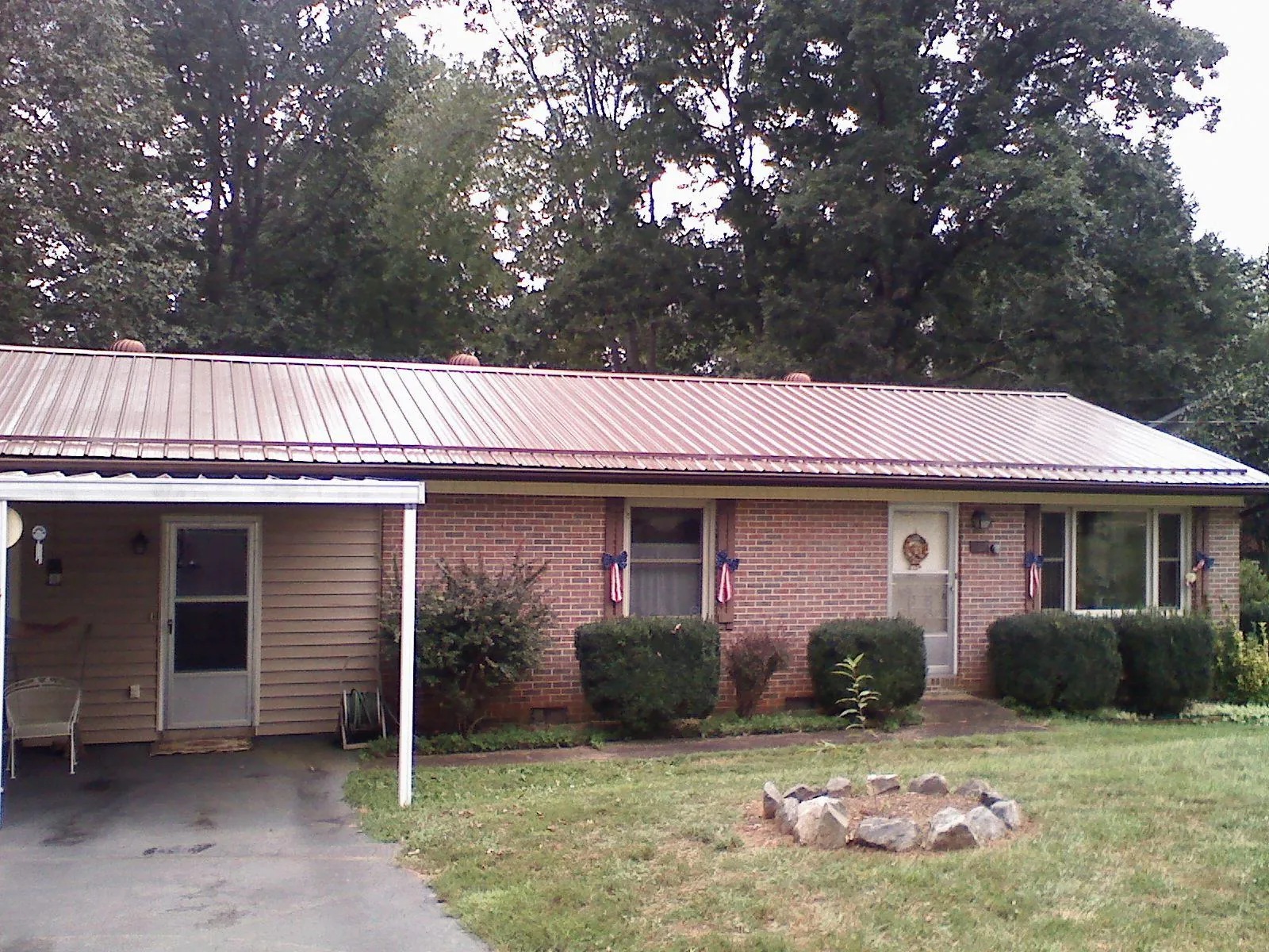 Bronze metal roof and carport on a brick ranch home — Roof Repair work by our crew in Woodland Park